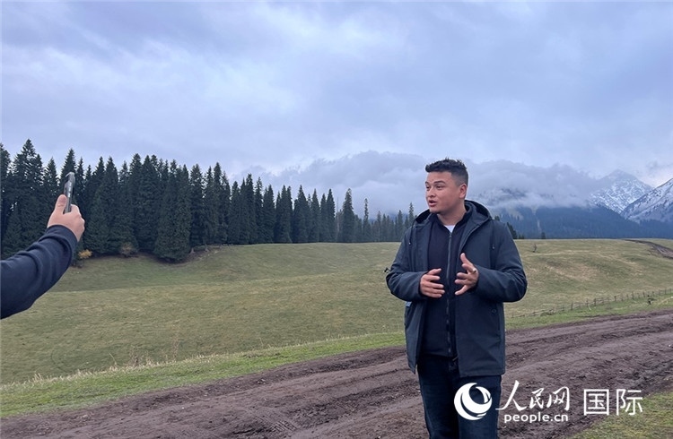 在庫爾德寧，吾買爾江被雪山美景震撼，即興錄制了短視頻作品。人民網記者曾書柔攝