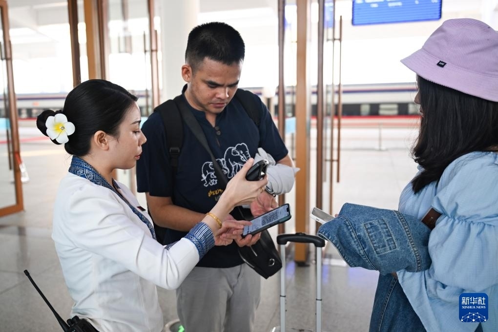 10月12日，在老撾萬象中老鐵路萬象站，工作人員檢驗乘客車票。新華社記者 程一恒 攝