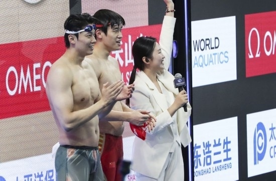  10月18日，汪順（左）和潘展樂在男子100米混合泳決賽后。新華社記者 方喆 攝