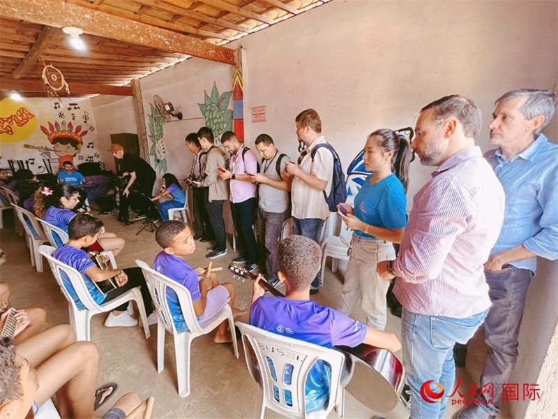  受益于中國企業(yè)的“青少年成長”項目，700多名當(dāng)?shù)厍嗌倌甑囊魳泛妥闱驂粝氩迳狭顺岚?。圖為聯(lián)合采訪團(tuán)正在采訪參加音樂培訓(xùn)的孩子們。 人民網(wǎng)記者 陳一鳴攝