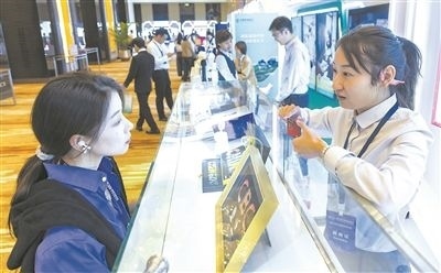 在北京麗澤商務(wù)區(qū)，工作人員（右一）介紹數(shù)字人民幣SIM卡硬錢包。新京報記者 陶冉攝