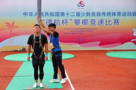 11月23日，工作人員為上海隊選手付樂樂（左）系安全繩。新華社記者 楊植森 攝