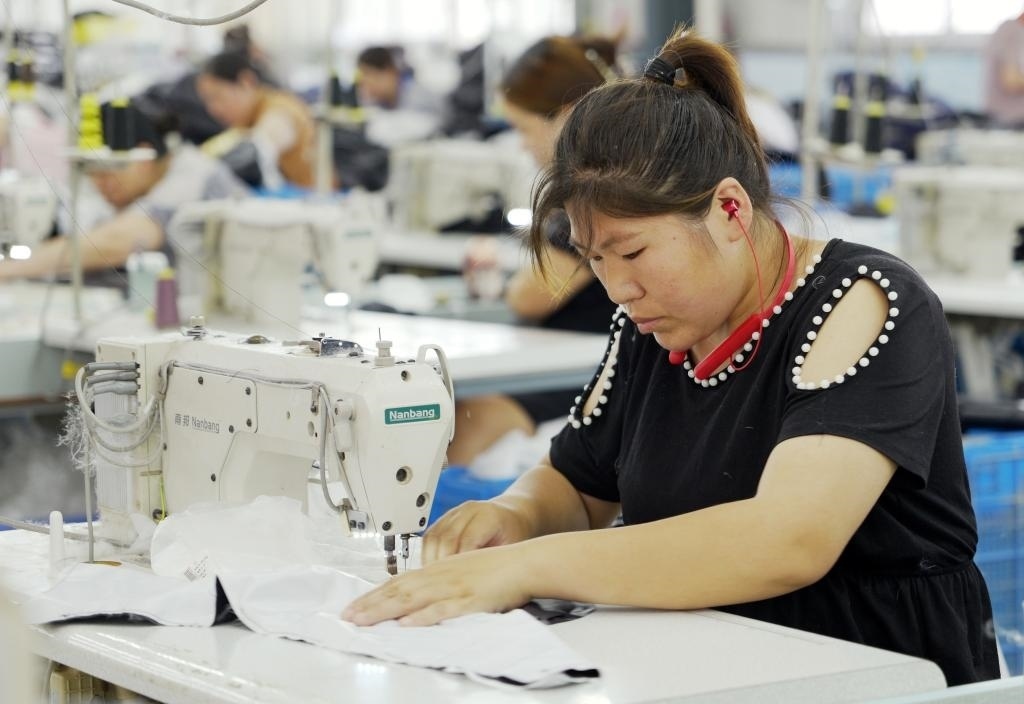 5月20日，村民在李寨村服裝加工廠內(nèi)忙碌。河南省周口市沈丘縣馮營(yíng)鎮(zhèn)李寨村地處豫東平原。近年來(lái)，乘著脫貧攻堅(jiān)與鄉(xiāng)村振興政策的東風(fēng)，李寨村積極探索產(chǎn)業(yè)發(fā)展模式，通過(guò)“龍頭企業(yè)+村集體經(jīng)濟(jì)+農(nóng)戶”的方式，逐漸發(fā)展形成肉牛養(yǎng)殖、設(shè)施農(nóng)業(yè)、服裝加工、康養(yǎng)民宿等產(chǎn)業(yè)，以產(chǎn)業(yè)振興助力鄉(xiāng)村振興。新華社記者 李嘉南 攝