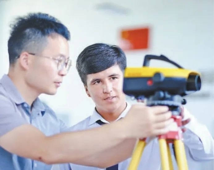 在塔吉克斯坦首都杜尚別的魯班工坊，來自天津城市建設(shè)管理職業(yè)技術(shù)學(xué)院的老師（左）為當(dāng)?shù)貙W(xué)生提供指導(dǎo)。新華社記者 鄭開君 攝