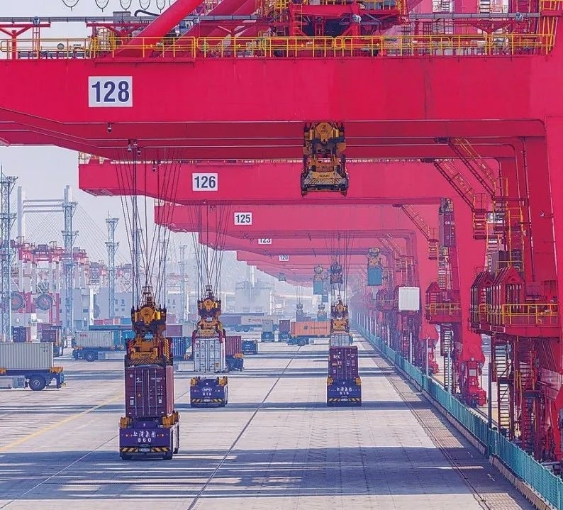 共建“一帶一路”國家在工作制度對接、技術(shù)標(biāo)準(zhǔn)協(xié)調(diào)、檢驗(yàn)結(jié)果互認(rèn)等方面強(qiáng)化合作、統(tǒng)一標(biāo)準(zhǔn)，貿(mào)易自由化便利化水平不斷提升。上海洋山港海關(guān)對接共建國家進(jìn)出口貨物相關(guān)標(biāo)準(zhǔn)，推動通關(guān)一體化方式申報(bào)，提升通關(guān)效率。圖為無人駕駛的全自動導(dǎo)引車在洋山港穿梭往來，搬運(yùn)集裝箱。王初 攝