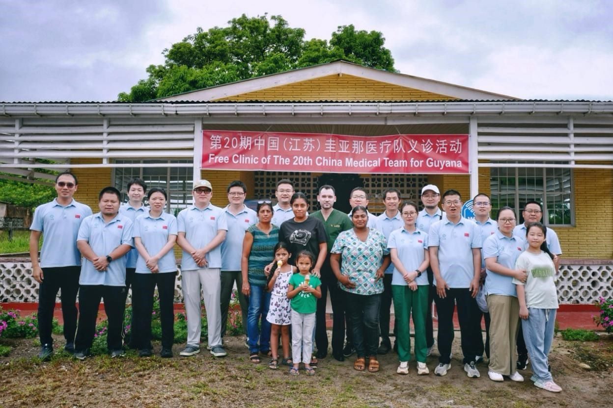 第20期中國(guó)（江蘇）援圭亞那醫(yī)療隊(duì)在圭偏遠(yuǎn)的林登高速社區(qū)開(kāi)展義診后，與部分當(dāng)?shù)鼐用窈嫌啊?中國(guó)援圭醫(yī)療隊(duì)供圖