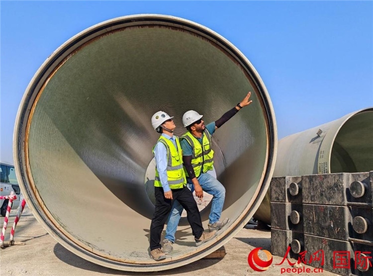 工作人員在察看輸水管情況。人民網(wǎng)記者 管克江攝