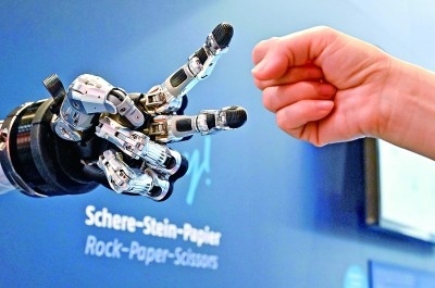 在德國漢諾威工博會(huì)上，參觀者與一款智能機(jī)器人進(jìn)行“石頭剪子布”游戲。新華社發(fā)