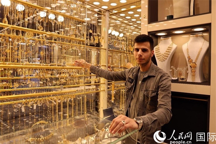一名銷售員展示黃金飾品。人民網(wǎng) 伊納斯·易卜拉欣攝