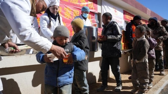 1月14日，廚師們正在給前來(lái)用餐的小朋友們打飯。新華社記者 邱星翔 攝