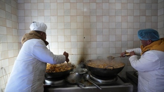 1月14日，服務(wù)隊(duì)的兩名廚師正在為村民們做午飯。新華社記者 邱星翔 攝