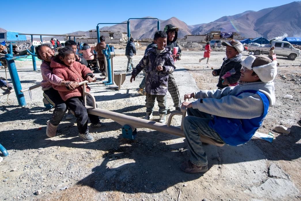 1月11日，在定日縣措果鄉(xiāng)塘仁村安置點(diǎn)，西藏星光社會(huì)工作服務(wù)中心志愿者和孩子們一起玩耍，進(jìn)行災(zāi)后心理疏導(dǎo)。人民網(wǎng)記者 翁奇羽攝