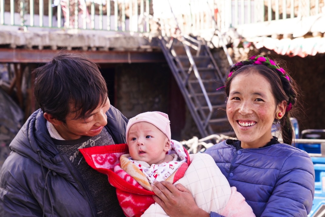 1月11日，在西藏日喀則市人民醫(yī)院，受災(zāi)群眾抱著自己在地震中受傷的孩子康復(fù)出院。人民日?qǐng)?bào)記者徐馭堯攝