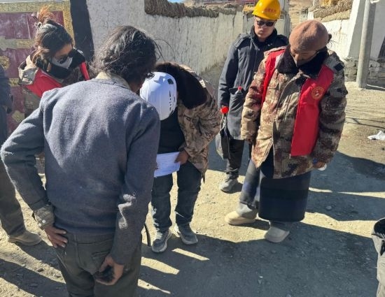 1月13日，次旺（右一）陪同工作組走訪村莊，評(píng)估房屋受損程度。新華社發(fā)