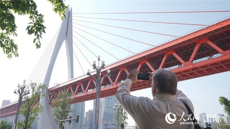 軻寶華“打卡”重慶東水門長江大橋。人民網(wǎng)記者 蘇纓翔攝