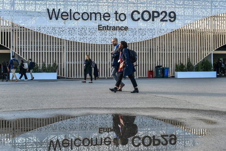 2024年11月15日，在阿塞拜疆首都巴庫，人們經(jīng)過聯(lián)合國氣候變化巴庫大會的會場。新華社記者 曹陽 攝