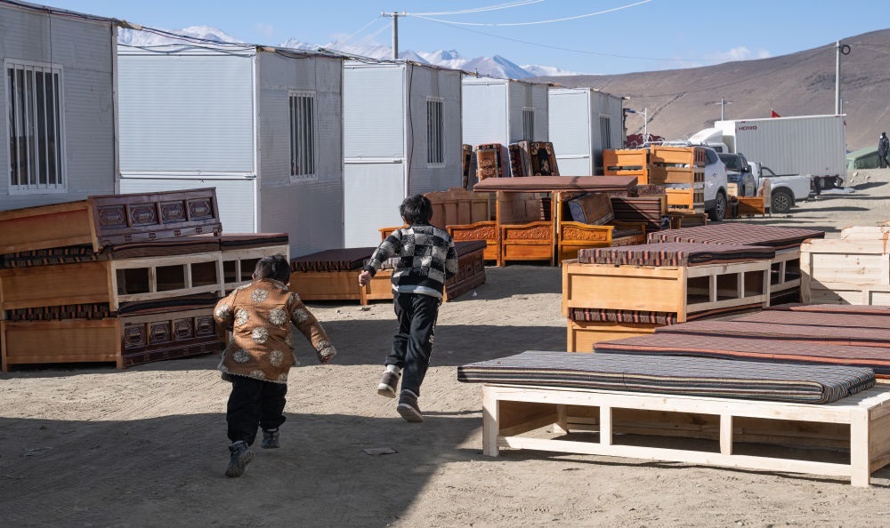 2025年1月13日，在定日縣嘎旦村，兩個孩子在剛運來的兩排藏床間奔跑。新華社記者丁增尼達(dá) 攝