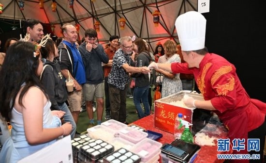 圖為游客在燈節(jié)現(xiàn)場(chǎng)購(gòu)買小吃。（圖片由奧克蘭中國(guó)文化中心提供）