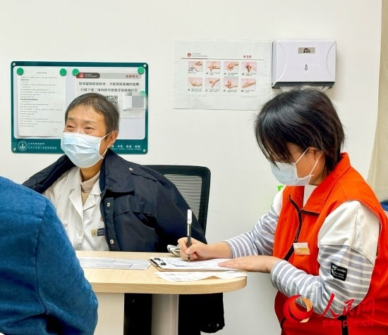 秦苑（中）接診患者。人民網(wǎng)記者 金慧慧攝