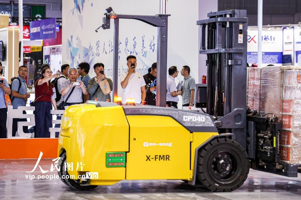 第24屆中國工博會(huì)現(xiàn)場，觀眾觀看叉取機(jī)器人作業(yè)演示。王初攝（人民圖片網(wǎng)）