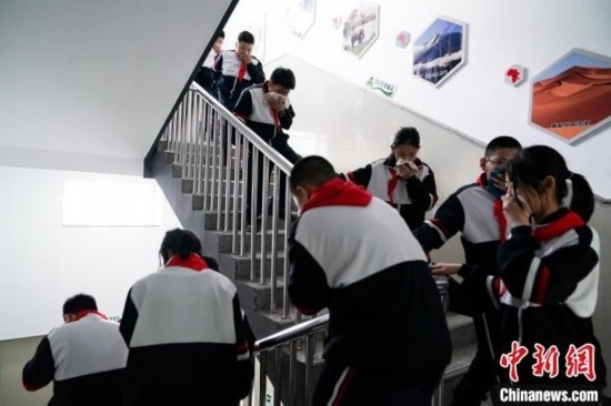  圖為學(xué)生們進(jìn)行應(yīng)急疏散演練。中新社記者 趙宇航 攝