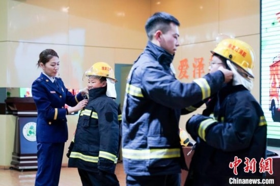 圖為學(xué)生們現(xiàn)場(chǎng)穿戴消防頭盔和戰(zhàn)斗服。中新社記者 趙宇航 攝