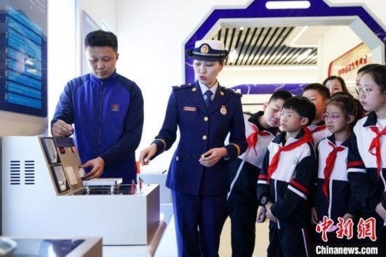 圖為學(xué)生們參觀道里區(qū)消防救援大隊(duì)消防科普體驗(yàn)館內(nèi)電器火災(zāi)演示實(shí)驗(yàn)臺(tái)。中新社記者 趙宇航 攝