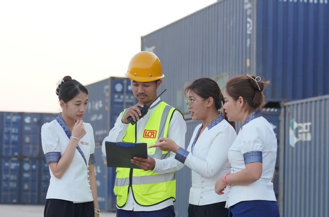 萬象南站貨運(yùn)值班員陳尼啦（左一）與同事在一起討論工作。老中鐵路有限公司供圖