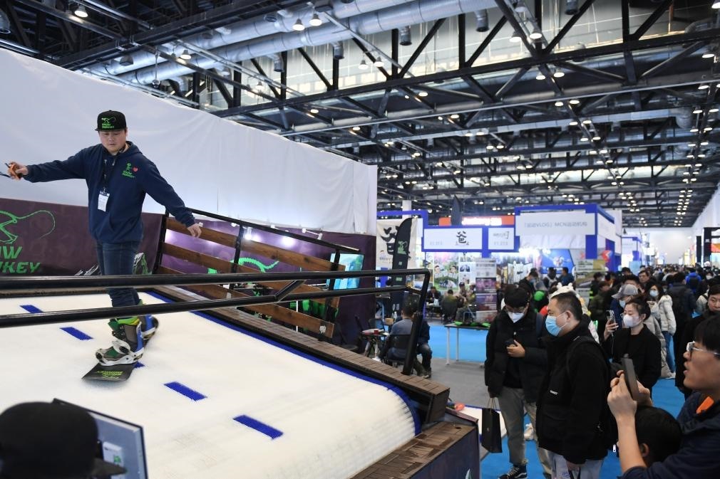 2023年2月11日，參觀者在展會上了解一款模擬滑雪設(shè)備。當日，2023亞洲運動用品與時尚展在國家會議中心拉開帷幕。新華社記者 張晨霖 攝