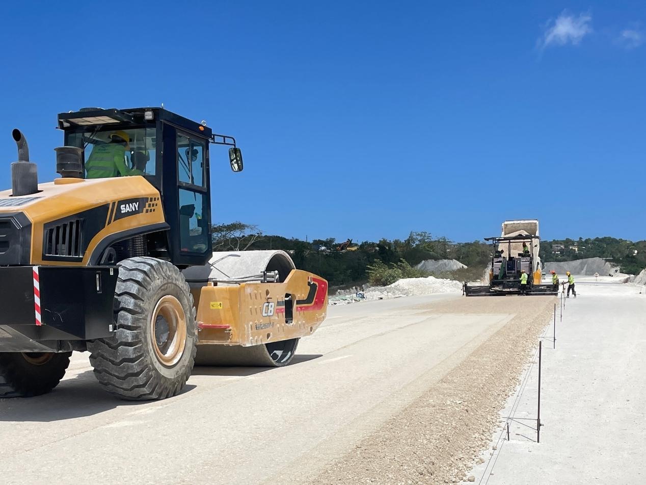 圖為中企承建的牙買加蒙特哥貝繞城路項(xiàng)目基層試驗(yàn)段正在進(jìn)行攤鋪和碾壓施工，相關(guān)施工工作已于日前順利完成。中國港灣美洲區(qū)域公司供圖