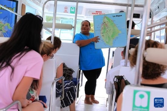 3月15日，一名導(dǎo)游在游艇上為游客介紹塞舌爾拉迪格島。新華社記者 董江輝 攝