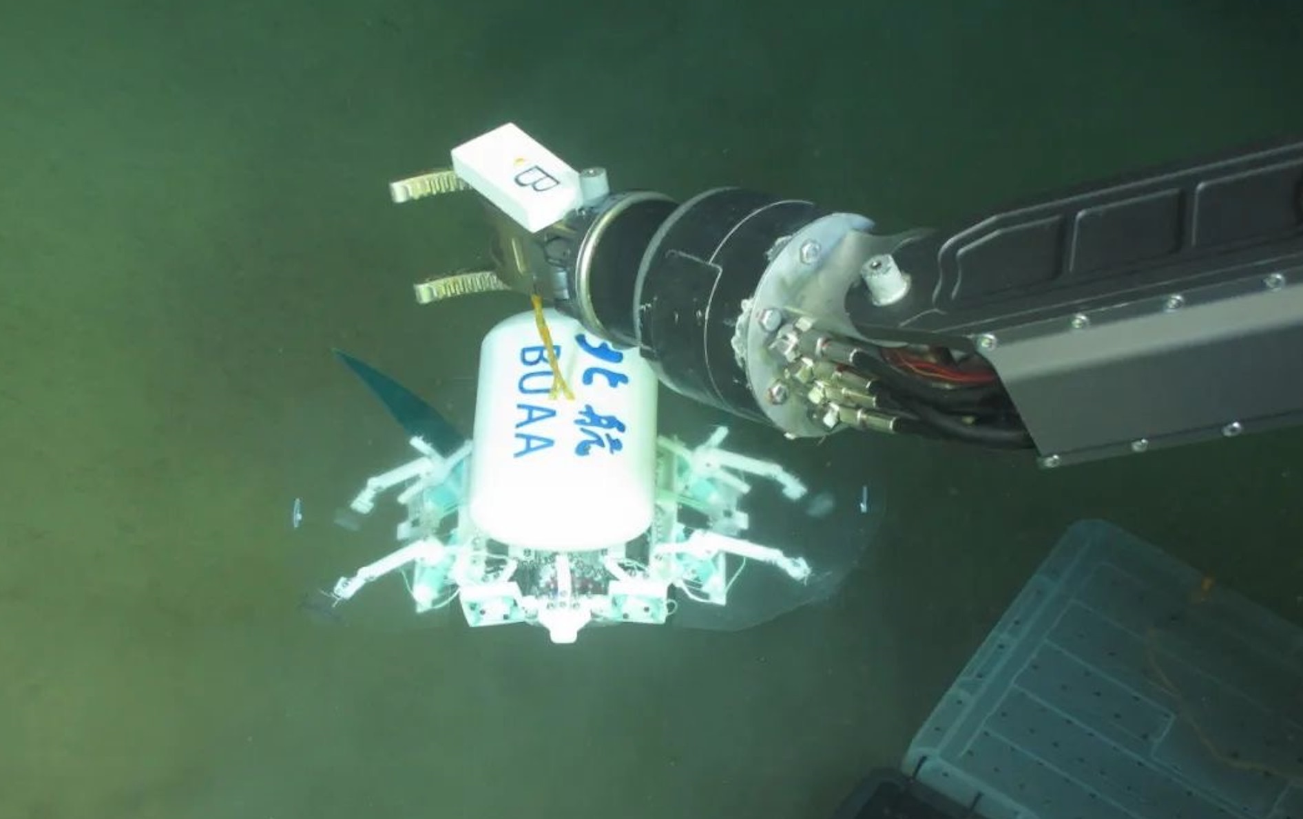 科研人員利用機(jī)械臂將北航深海小型機(jī)器人投于馬里亞納海溝。校方供圖