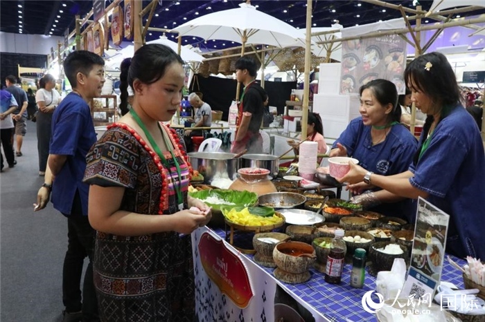 游客在攤位前購(gòu)買(mǎi)特色美食。朱瀟逸攝