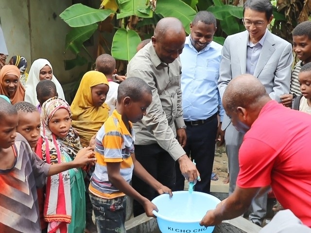在日前舉行的安全供水工程揭牌儀式上，當(dāng)?shù)匦∨笥言诠┧c(diǎn)接水。 施亮攝