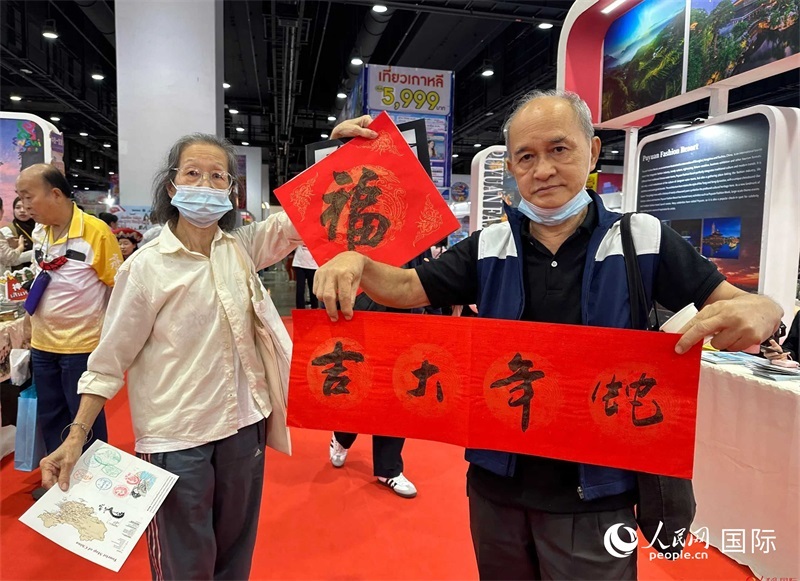 2025蛇年春節(jié)，泰國市民展示他們領(lǐng)到的華人手寫春聯(lián)。人民網(wǎng)記者 簡承淵攝