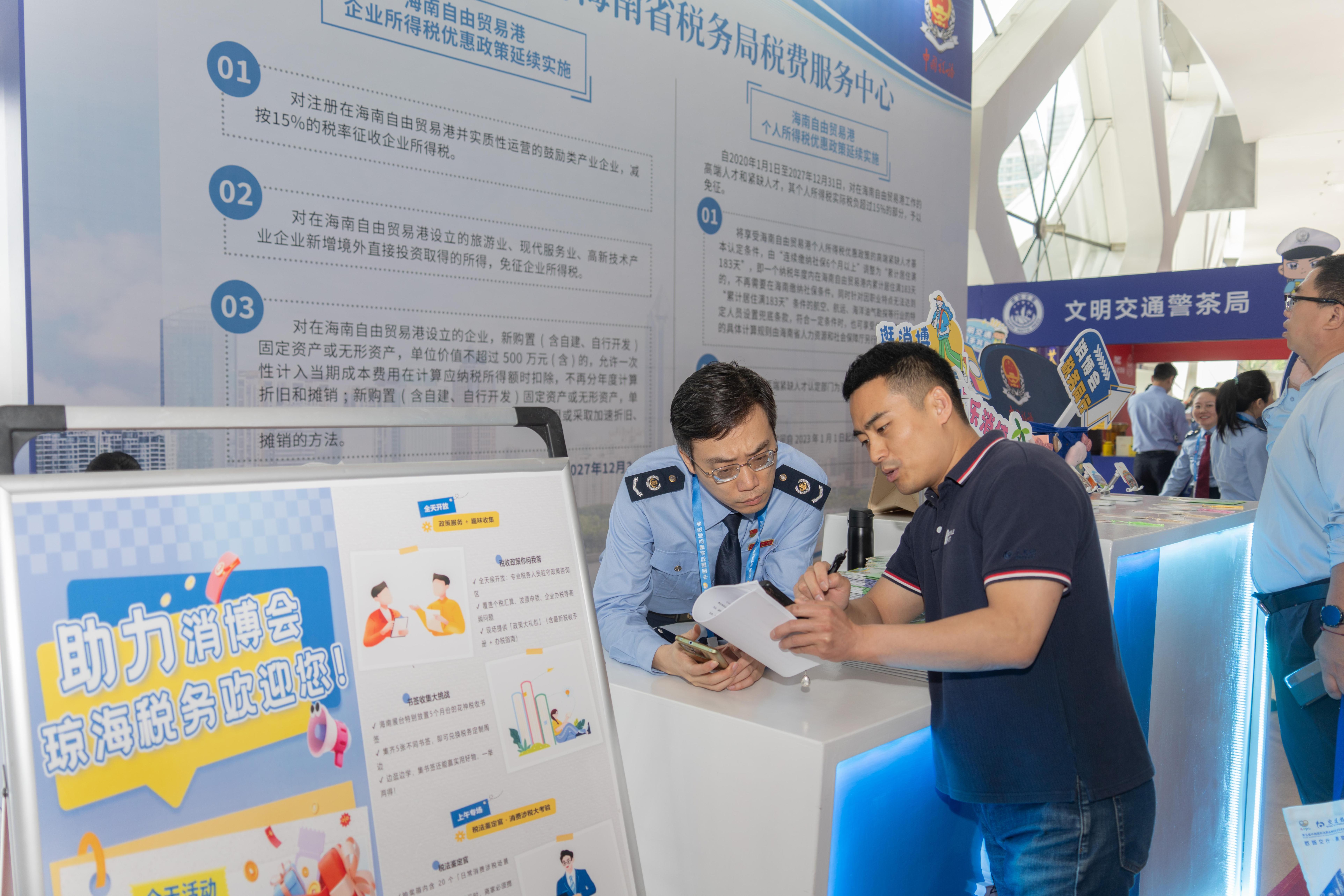 稅務(wù)服務(wù)臺工作人員向記者介紹服務(wù)參展外商的具體舉措。人民網(wǎng)記者 許崢攝