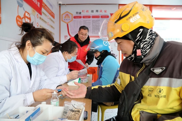 2025年3月5日，志愿者在山東省棗莊市市中區(qū)一工會驛站為外賣員免費測量血糖。新華社發(fā)（王海楠攝）