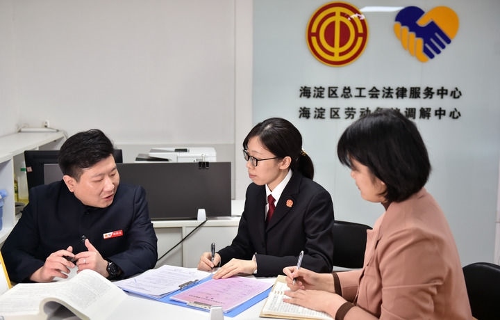 2025年3月6日，在北京市海淀區(qū)總工會勞動爭議調(diào)解中心，海淀區(qū)人民法院法官王琰（中）與該中心工作人員就糾紛化解情況進行溝通。新華社記者 趙婷婷 攝