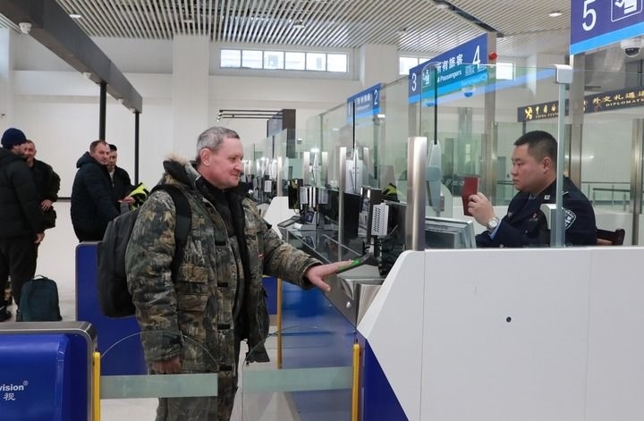 2024年12月10日，在黑河公路口岸旅檢大廳，黑河出入境邊防檢查站民警為首班次客車入境旅客辦理邊檢通關(guān)手續(xù)。當日，中國黑河公路口岸—俄羅斯卡尼庫爾干公路口岸旅客運輸正式開通。新華社發(fā)（劉松攝）