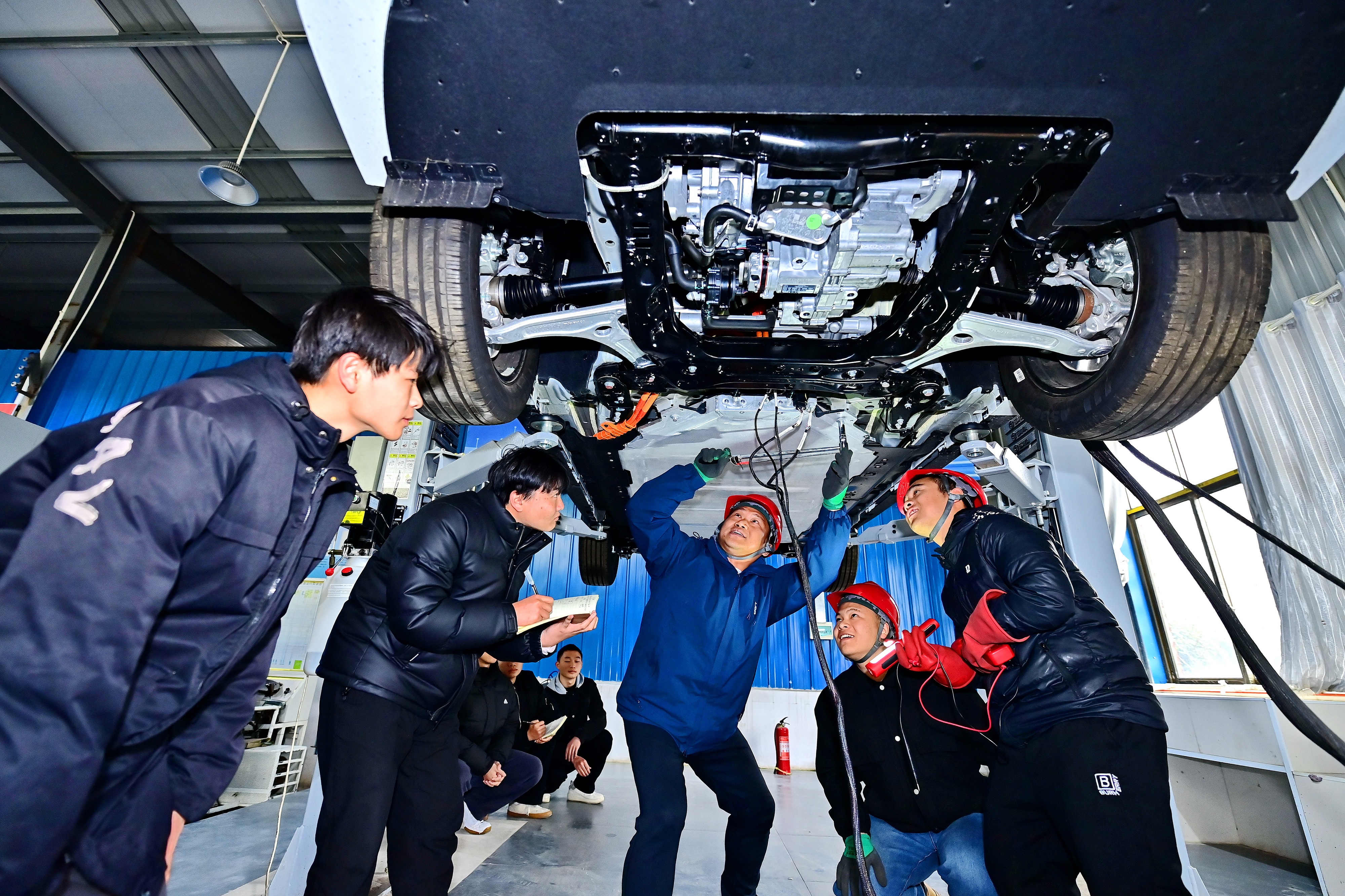 2025年2月，江西省宜春市，豐城市的一所技工學校實訓基地內(nèi)，新能源汽車運維專業(yè)學生在老師的指導下學習新能源汽車電池包檢修技術(shù)。