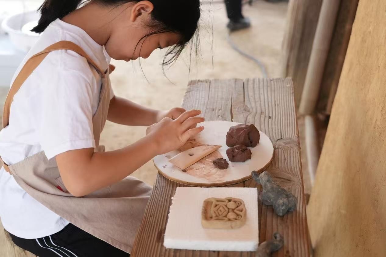 游客制作良渚特色陶藝品。良渚博物院供圖