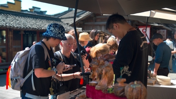 “五一”期間，游客正在烏鎮(zhèn)“水鄉(xiāng)碼頭”挑選購買文創(chuàng)產(chǎn)品。受訪者供圖