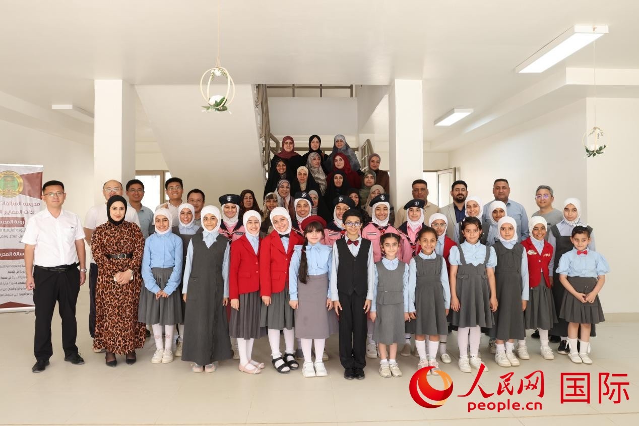 中國電建員工與阿爾穆塔?阿里卡特國際學校的師生及政府官員等合影。人民網(wǎng)記者 薛丹攝