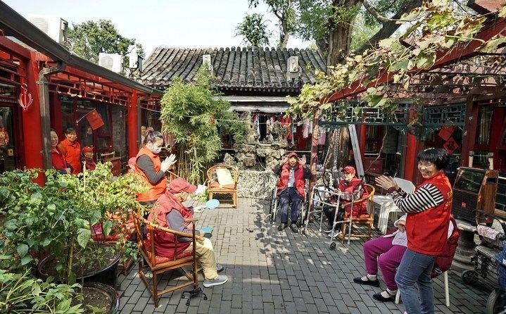 2024年10月12日，鐘樓灣胡同的老年人在社區(qū)內(nèi)的四合院養(yǎng)老驛站休閑。2017年起，北京市先后開展了兩輪背街小巷環(huán)境整治提升行動，完整保留了中軸線生活建筑群的歷史信息，并根據(jù)居民的生活和居住方式進行適配化的更新和改造，極大地改善了生活環(huán)境。2023年鐘樓灣胡同被評為“北京最美街巷”。