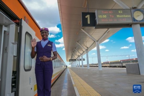 5月31日，在蒙內(nèi)鐵路內(nèi)羅畢站，一名乘務(wù)員在即將開(kāi)往蒙巴薩的E2次列車旁等候乘客。新華社記者 楊光 攝