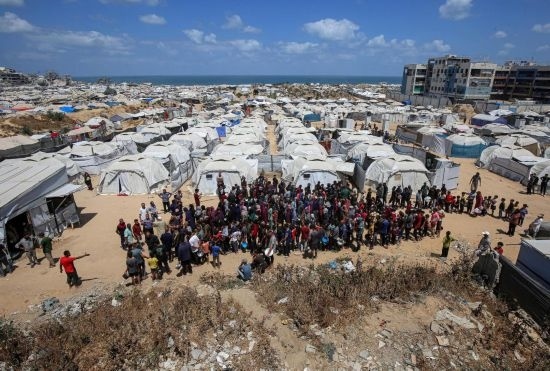5月28日，人們在加沙城西部的沙提難民營等待領取救助食物。新華社發(fā)（里澤克·阿卜杜勒賈瓦德攝）