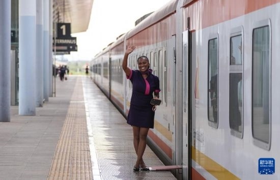 5月31日，在蒙內(nèi)鐵路內(nèi)羅畢站，一名乘務(wù)員在即將開(kāi)往蒙巴薩的E2次列車旁等候乘客。新華社記者 李亞輝 攝
