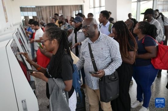 5月31日，在蒙內(nèi)鐵路內(nèi)羅畢站，乘客在自助取票機(jī)前排隊(duì)取票。新華社記者 楊光 攝