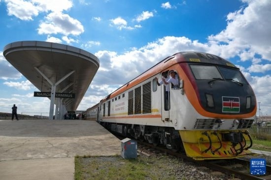 5月31日，在蒙內(nèi)鐵路內(nèi)羅畢站，機(jī)車駕駛員蔣立平（右）和博爾在即將開(kāi)往蒙巴薩的E2次列車上揮手致意。新華社記者 楊光 攝