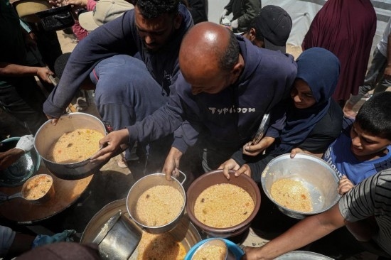 5月28日，人們在加沙城西部的沙提難民營領取救助食物。新華社發(fā)（里澤克·阿卜杜勒賈瓦德攝）